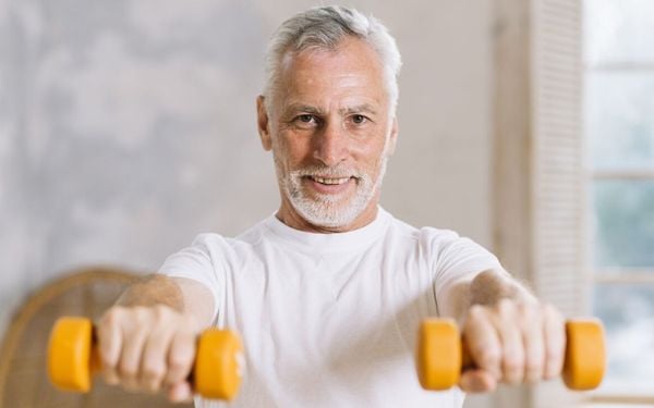 homem de 50+ levantando pesos