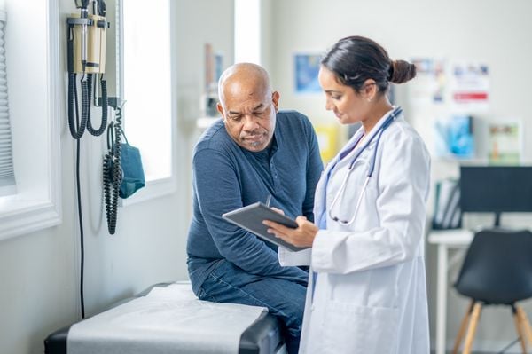 Paciente masculino olhando os exames com uma médica mulher