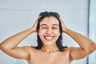 mulher lavando os cabelos no chuveiro