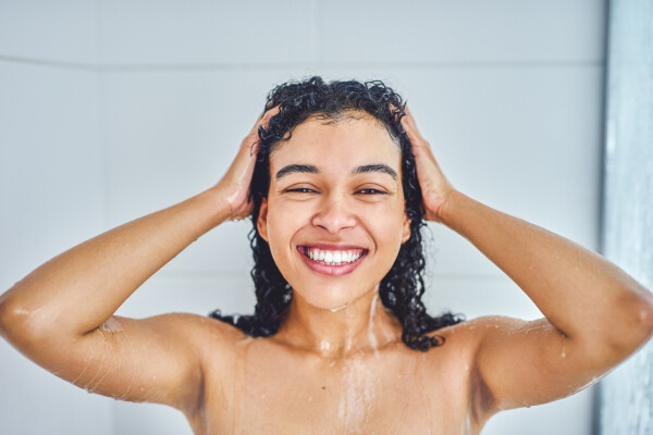 mulher lavando os cabelos no chuveiro