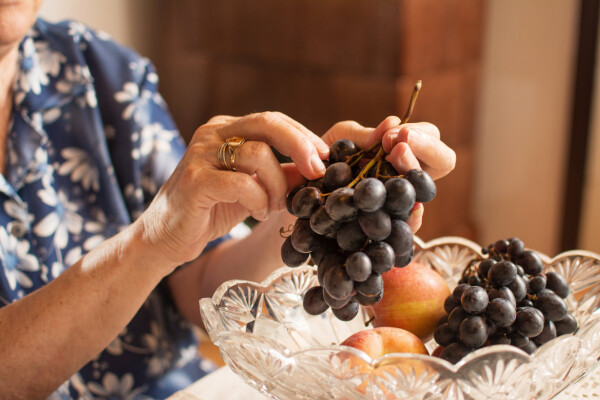 Mulher tirando a uva do cacho de uva