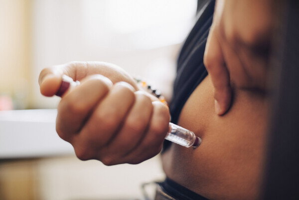 Imagem aproximada de mulher aplicando medicamento injetável para diabetes tipo 2 na barriga