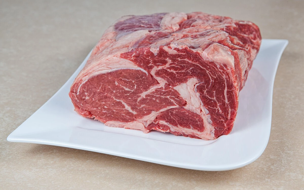 Prato com peça grande de carne bovina crua
