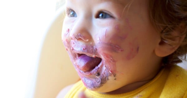 Bebê com o rosto sujo de comida
