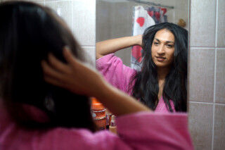 Mulher trans se olhando no espelho