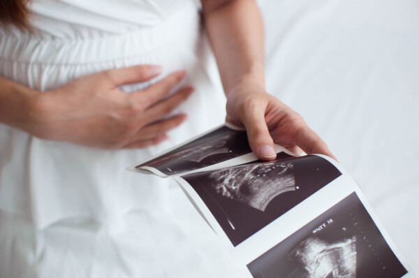 Mulher grávida segurando ultrassom
