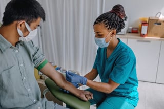 Enfermeira preparando paciente para retirar sangue