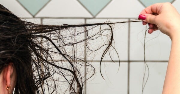 mulher passando chapinha no cabelo