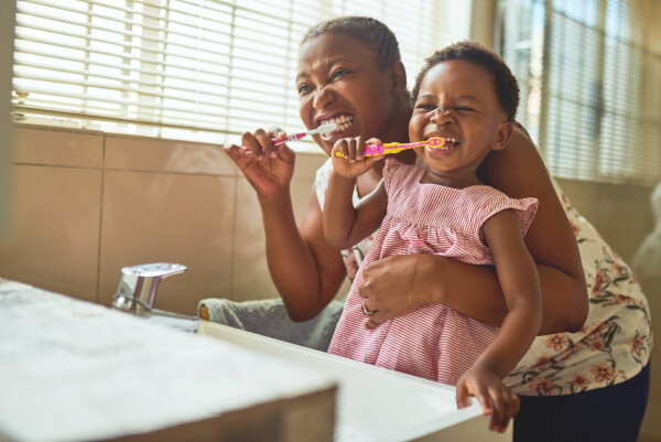 Mãe e filha escovando os dentes
