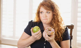 Mulher em dúvida entre doce e fruta - Foto Getty Images