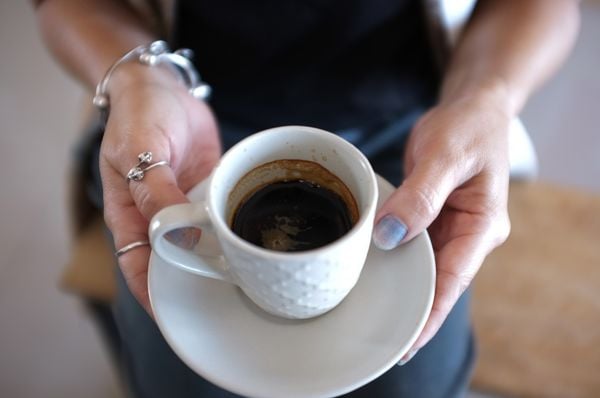 Close up mãos femininas segurando um xícara de café