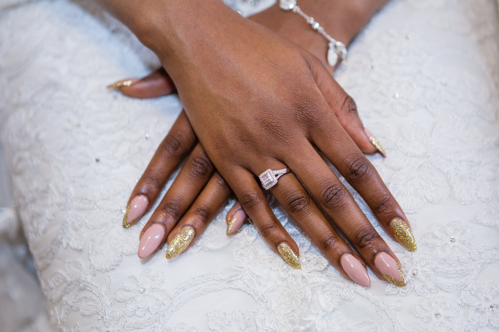 Detalhe das mãos de uma manicure pintando as unhas com um desenho de  esmalte preto