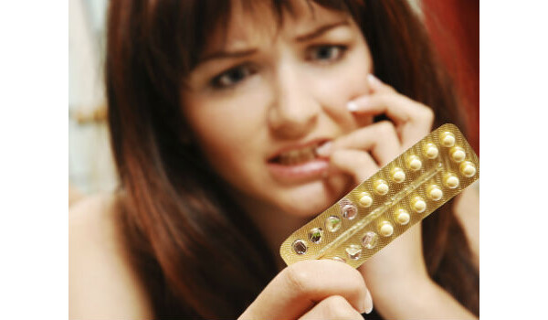 mulher segurando uma cartela de pílula