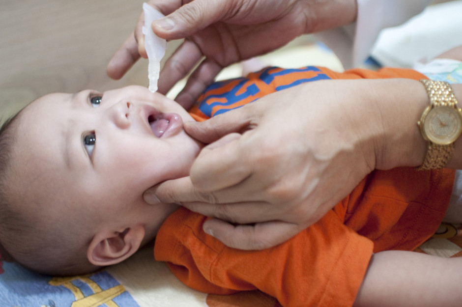 Bebê recebendo dose da vacina oral contra a poliomielite