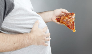 homem com obesidade comendo pizza - Foto: Getty Images