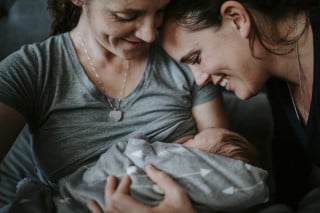 Mãe amamentando seu bebê enquanto outra mãe olha para o bebê