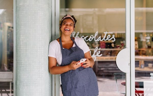 mulher sorrindo com o celular na mão