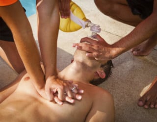 Pessoas fazendo massagem cardíaca em homem