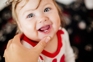 Menina bebê com dentinhos nascendo na boca