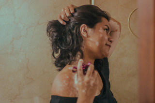 mulher aplicando perfume no pescoço