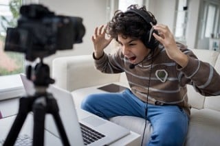Menino jogando videogame pelo notebook - foto: Getty Images