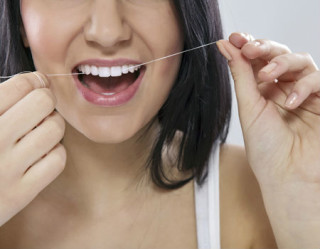 mulher passando fio dental