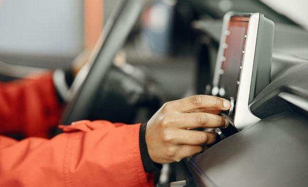 Mão de uma pessoa abaixando o som do carro