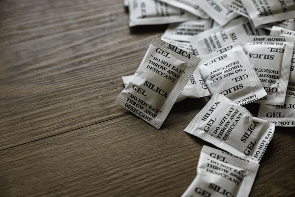 Diversos sachês de silica em gel sobre mesa de madeira