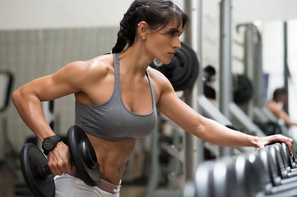 Mulher fazendo musculação na academia