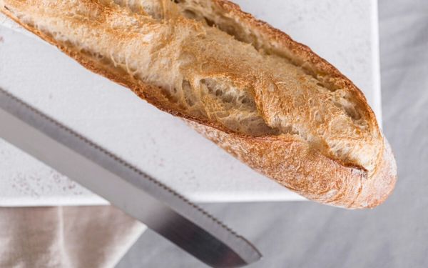 foto de pão francês e uma faca de pão