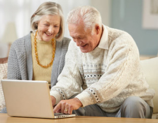 casal de idosos usando computador
