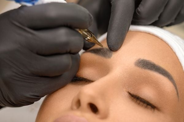 Mulher fazendo procedimento de micropigmentação na sobrancelha