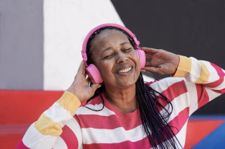 Mulher negra feliz ouvindo música - Foto: Shutterstock
