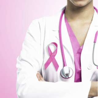 médica com um laço rosa na roupa - Foto: Getty Images