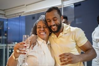 Homem e mulher abraçados, felizes, com taças nas mãos