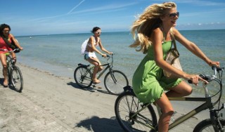 Mulheres andando de bicicleta na praia - Foto Getty Images