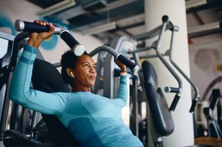 Mulher fazendo musculação na academia