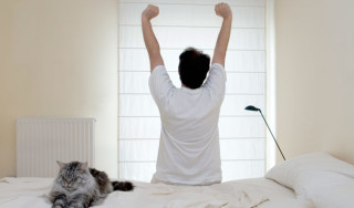 Homem fazendo alongamento na cama - Foto: Getty Images