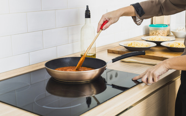 Imagem aproximada de pessoa cozinhando em frigideira