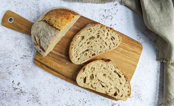 Três pedaços de pão em uma tabua de madeira