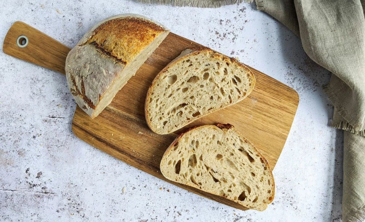 Três pedaços de pão em uma tabua de madeira