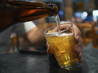 Pessoa colocando cerveja em um copo americano