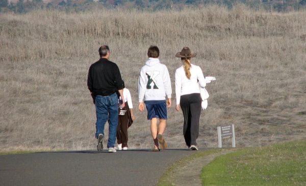 Steve Jobs caminhando acompanhado de duas pessoas