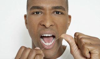 Homem fio dental antes de escovar os dentes Foto: GettyImages