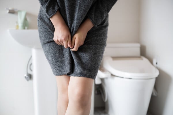 Mulher no banheiro com problemas de infecção urinaria
