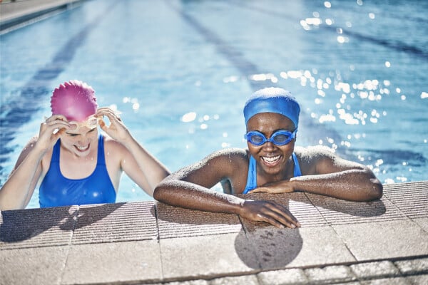 Duas mulheres na piscina com equipamentos de natação