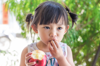 Criança comendo maçã