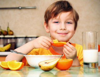 Criança comendo fruta e leite