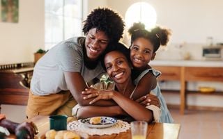 mãe e filhos dando um abraço