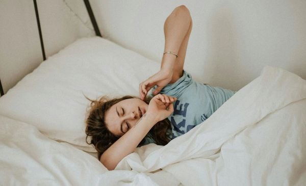 Mulher se espreguiçando na cama